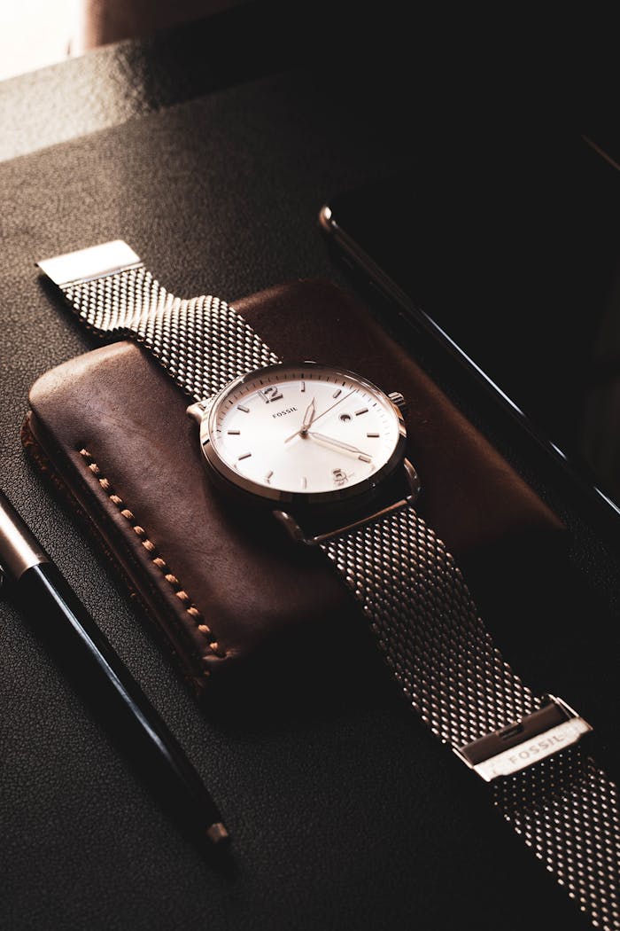 Close-up of a sophisticated wristwatch resting on a leather wallet, captured with a minimalistic touch.
